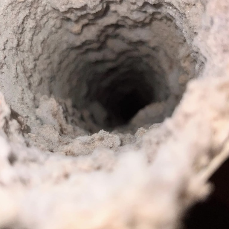Dryer vent before cleaning with heavy lint buildup inside the duct